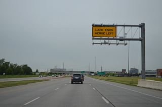A lane drop occurs along I-94/U.S. 52 west ahead of the entrance ramp from southbound I-29/U.S. 81. Merging traffic forms a third westbound lane to Exit 348 with 45th Street.