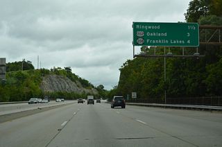 An interchange sequence sign precedes Exit 57 with Skyline Drive (CR S91) and the borough of Oakland. U.S. 202 returns to I-287 at the second Oakland exit.