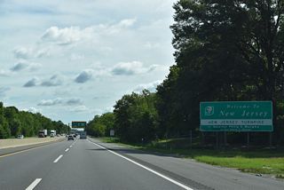 Paralleling U.S. 40 (Wiley Road) just to the north, the New Jersey Turnpike spans Game Creek beyond a welcome sign.