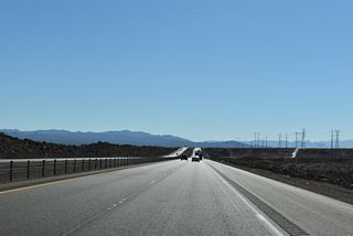Seven miles into the Silver State, I-11/U.S. 93 curve southwest across northern reaches of Eldorado Valley over desert terrain and outside the Boulder City urban area.