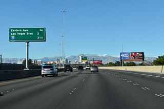 Curving west across Stewart Avenue and Pecos Road, Downtown Las Vegas comes into view along Interstate 11 northbound ahead of Exit 73 for Eastern Avenue.