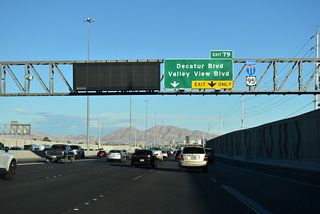 The parclo interchange with Decatur Boulevard falls between Lima Vista Shopping Center and Western High School.