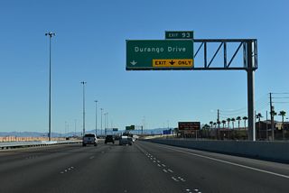 Durango Drive angles southwest from Grand Teton Drive to a parclo interchange with I-11/U.S. 95 at Exit 93.