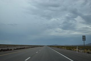A reassurance marker stands precedes unpaved ranch road tieing into U.S. 95 from the east near Clark County milepost 37.