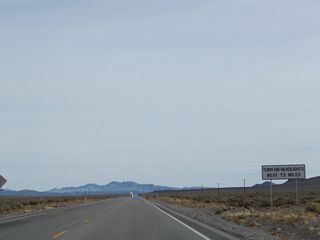 Another head light requirement sign stands just south of a military access road intersecting U.S. 95 near Nye County milepost 79.