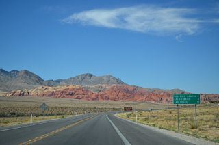 Distance sign posted north of the Red Rocks National Conservation Area Scenic Drive south end.