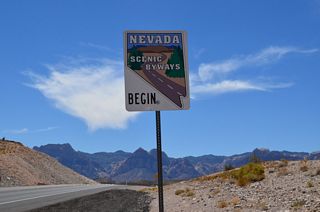 Removed by 2017, a Nevada Scenic Byways trailblazer marked the beginning of the scenic route along SR 159 by the Red Rock Canyon sign.