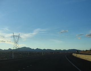 A power transmission line crosses over Nevada 163 (Laughlin Highway) as the state route ascends out of Laughlin and the Colorado River valley.