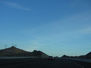 A 500kV power line (Southern California Edison) crosses over Nevada 163 ahead. The line connects a (defunct) power generating station in Laughlin with the electrical grid to the north of here. This particular line turns north to meet the rest of the grid at the Marketplace Substation near Nevada Solar One west of U.S. 95.