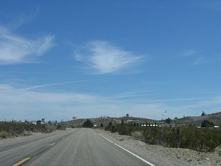 After passing under the power lines, eastbound Nevada 164 reaches the unincorporated town of Searchlight. Most motorist services (food, gas, lodging) are available in Searchlight.