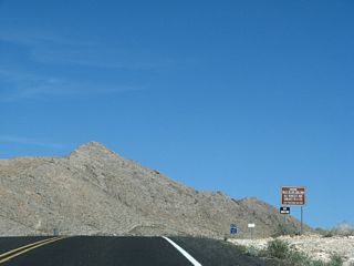 The Valley of Fire Highway enters the Valley of Fire State Park. This is the oldest state park in the Nevada park system. Founded in 1935, this park is popular for its red sandstone formations. None of these startling formations are visible at the entrance to the park.