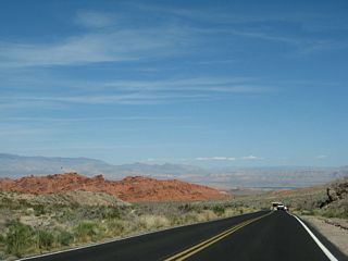 A large red sandstone formation comes into view as the Valley of Fire Highway passes by the entrance station. Roadside parking areas are available for hiking and closer inspection of the red cliffs.