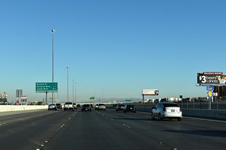 Commercial retail and apartment complexes line CC-215 ahead of Exit 16 to Buffalo Drive.