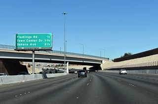 Fort Apache Road spans CC-215 ahead of Flamingo Road. Sahara Avenue and Desert Foothills Drive come together at the freeway in 3.5 miles.