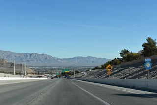 This view shows the Fossil Ridge mountain range along the northern horizon from where northbound CC-215 descends 300 feet in elevation toward Exit 30 for Cheyenne Avenue. Cheyenne Avenue is the final exchange for Summerlin.   