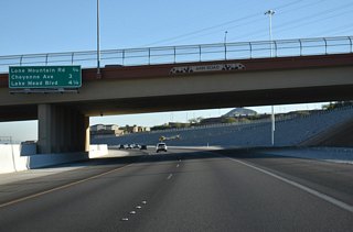 The Bruce Woodbury Beltway travels under Ann Road three quarters of a mile ahead of Exit 32 to Lone Mountain Road.
