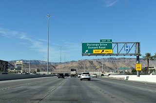 The split diamond (Exit 17) interchange with Durango Drive and Sunset Road along CC-215 west. Durango Road heads 1.3 miles north to meet Russell Road and south 0.7 miles to Warm Springs Road.