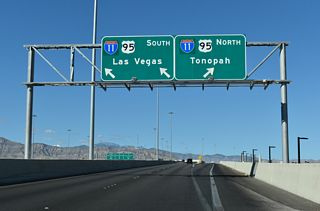 Opened July 12, 2017 at a cost of $47 million, a 2,500 foot long flyover ramp leads onto a c/d roadway ahead of Ann Road and Rancho Drive (SR 599) along I-11/U.S. 95 south. Rising to 60 feet in height, the ramp also represents the pinnacle of the exchange (Marroquin, 2017).