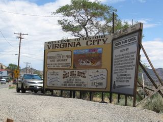 A billboard style welcome sign for Virginia City references some of the tourist attractions, such as the adjacent Fourth Ward School and Gold Hill Hotel.