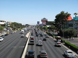 After Las Vegas Boulevard, this view shows eastbound Nevada 593 (Tropicana Avenue) as the multi-lane road travels through the unincorporated community of Paradise. Nevada 593 will pass along the northern edge of McCarran International Airport and the southern edge of the University of Nevada at Las Vegas (UNLV) between the Las Vegas Strip and Maryland Parkway.