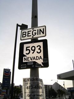 The former eastbound beginning of Nevada 593 along eastbound Tropicana Avenue at Dean Martin Drive, prior to the interchange with Interstate 15. Dean Martin Drive (former Industrial Road) acts as a frontage road on the west side of I-15. The skyline of the New York New York resort and the Las Vegas Strip dominate the view looking east.