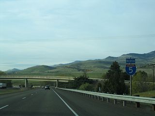 The first Interstate 5 northbound reassurance marker in Oregon appeared beyond the entrance ramp from OR 66 (Ashland Street) at Exit 14. Main Street passes over the freeway ahead.