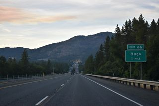 Monument Drive, the old alignment of U.S. 99 north from Merlin Road, converges with I-5 at Exit 66. Oxyoke Road stems north from nearby to the community of Hugo. Formerly named &quot;Gravel Pit&quot;, Hugo was established as a flag station along the Oregon and California Railroad in 1883. A post office commenced operations at the site in 1895. Hugo derives its name from Hugo Garbers, a long time area farmer. The area was known for cherry harvests through the 20th century.