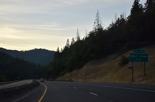 I-5 lowers into the unincorporated Wolf Creek at a split diamond interchange (Exit 76) with Old Highway 99 and Coyote Creek Road. Founded in 1872 by Henry Smith, Wolf Creek grew as a lumber and supply center for the Wolf Creek and Coyote Creek mines. The Oregon and California Railroad built a station at the settlement.