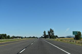 Interstate 5 proceeds north across flat agricultural areas into Linn County. Rising nearby to the east is West Point Hill, one of several low, oak and fir-covered hills that are representative of the southern Willamette Valley.