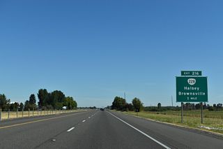 Advancing north across farm land, Interstate 5 meets OR 228 (Halsey-Sweet Home Highway) at a diamond interchange (Exit 216) in one mile.