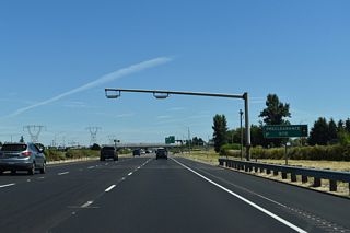 A preclearance site for commercial trucks precedes the six-ramp parclo interchange (Exit 217) with OR 219/214 (Hillsboro-Silverton Highway).