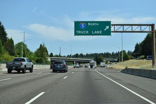 A truck lane splits from the I-5 mainline just past Exit 294. According to ODOT, the lane was added in 1983 to keep slow-moving trucks, heading up a moderate grade, to the outside of a flyover ramp merging onto northbound I-5 from OR 99W.