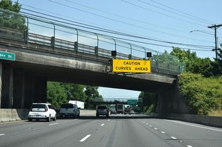 This sign at the Spring Garden Street overpass warns motorists of the upcoming "Terwilliger Curves", a series of sharp S-curves south of the Hillsdale District.