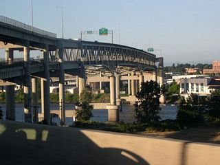 Northbound I-5 traffic along the Marquam Bridge travels on the upper deck of  steel-truss cantilever bridge across the Willamette River.