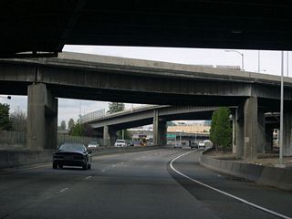 I-5 northbound passes under the knot of ramps taking traffic to and from the Morrison Bridge. There is no direct access to the bridge from northbound I-5; the ramps originate mostly from surface streets and the bridge itself. The Morrison Bridge connects west side Washington and Alder streets with east side Morrison and Belmont streets.