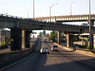 Northbound I-5 passes under the flyover ramp bringing traffic from westbound I-84 to southbound I-5. The flyover just beyond carries traffic from southbound I-5 to eastbound I-84.