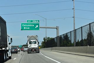 Interstate 5 spans a Union Pacific Railroad line travels as it reaches Exit 306 A for Columbia Boulevard. Columbia Boulevard travels through mostly commercial and light industrial areas spreading south of the Columbia River.