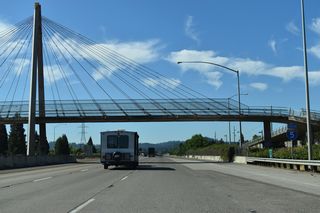 A pedestrian bridge spans Interstate 5 by The Shoppes at Gateway (formerly Gateway Mall) retail center.