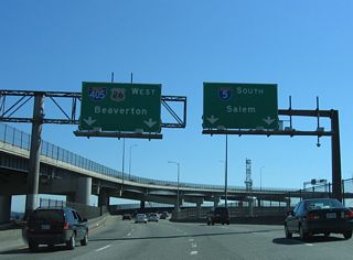 I-5 south crosses the Willamette River and meets I-405 (Stadium Freeway) at the west end of the Marquam Bridge. The mainline departs southward ahead of Harbor Drive as Interstate 405 takes over from the left to encircle the city center.