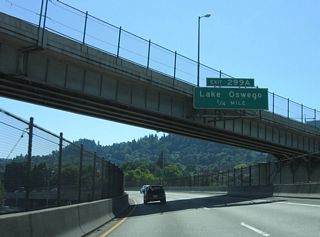 Turning southward, Interstate 5 overtakes S Harbor Drive and I-405 ahead of the Ross Island Bridge (U.S. 26). Exit 299 A departs ahead of Harbor Drive onto parallel OR 43 (SW Hood Avenue). OR 43 runs 11.68 miles south to Lake Oswego and West Linn.