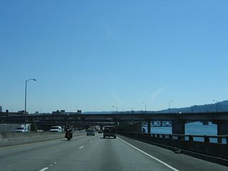 I-5 lowers from the viaduct that started at Multnomah Street to grade level south of the Burnside Bridge. The freeway parallels the Willamette River directly from I-84 to the Marquam Bridge. A stub on the flyover from Exit 301 is from a removed ramp between Interstate Avenue at the Steel Bridge. A stub also exists on ramp from the Banfield Expressway to I-5 north that once connected with Glisan Street. These ramps were removed after 1990.