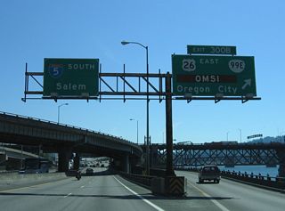 Exit 300 B leaves I-5 south ahead of the Burnside Bridge (former U.S. 30 Business). Interests to Oregon Museum of Science and Industry (OMSI) are directed onto OR 99E south to Clay Street west. OR 99E continues southeast to Oregon City via McLoughlin Boulevard.