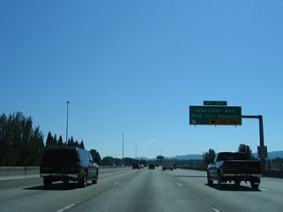 Continuing south, I-5 runs along West Delta Park to Portland International Raceway and Denver Avenue (former OR 99W). Denver Avenue branches southwest from Exit 306 to the Kenton neighborhood of Portland, becoming Interstate Avenue south of Columbia Boulevard.