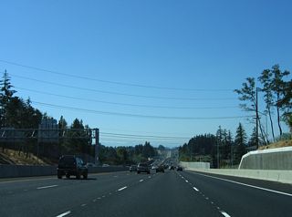 West from the parclo interchange (Exit 68) with Cedar Hills Boulevard, U.S. 26 (Sunset Highway) lowers to cross Johnson Creek.