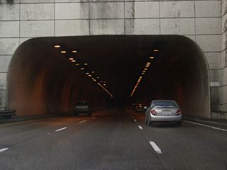 The Vista Ridge Tunnel passes through a hill below SW Montgomery Drive and SW Vista Avenue, two residential streets in the Goose Hollow neighborhood.