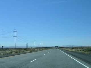 Interstate 82 separates Umatilla Army Depot from agricultural areas ahead of Exit 10. The adjacent power line corridor turns eastward alongside Lamb Road to a plant on Westland Road.