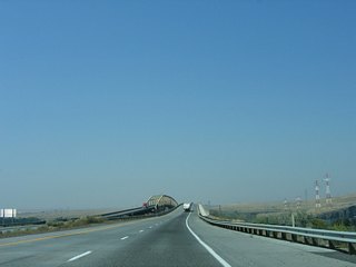 I-82/U.S. 395 crosses Lake Umatilla along the Columbia River at separate bridges. The original eastbound span carried two-way traffic as a toll bridge from 1955 to 1974. That span was upgraded for Interstate use when the concrete arch bridge for I-82 westbound opened to traffic.&sup1;
