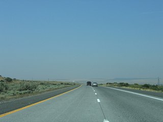 Hills in southern Washington appear along the northern horizon as Interstate 82 straddles eastern reaches of the city of Umatilla.