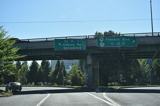 Traffic partitions at the east end of 7th Avenue for a ramp onto the Coburg Road viaduct northeast across the Willamette River to Martin Luther King Jr. Boulevard and I-105/OR 126. OR 99/126 curve south onto Mill Street for two blocks to make the connection with Broadway.