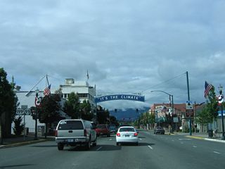 A confirming marker for OR 99 stands along 6th Street southbound beyond the Central Oregon &amp; Pacific Railroad at-grade crossing. U.S. 199 was removed from the assembly by 2012.